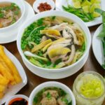 Traditional Vietnamese chicken noodle soup (Phở Gà) with fresh herbs, fried dough sticks, and chili – a must-try street food in Nha Trang.
