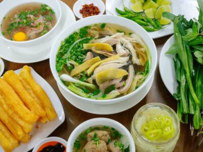 Traditional Vietnamese chicken noodle soup (Phở Gà) with fresh herbs, fried dough sticks, and chili – a must-try street food in Nha Trang.